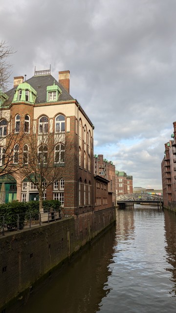 A decorated brick building. A canal. Brick warehouses.